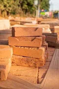 Cut red brick halves stacked one on top of another at a construction site. .. Stock Photos