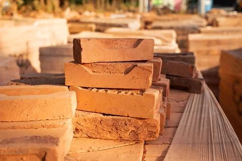 Cut red brick halves stacked one on top of another at a construction site. .. Stock Photos