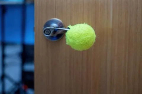 Cut rubber ball is creatively placed on a sharp door handle to prevent dama.. Stock Photos