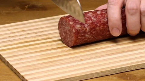 Cut sausage with a knife on a board. Stock Footage 70726853