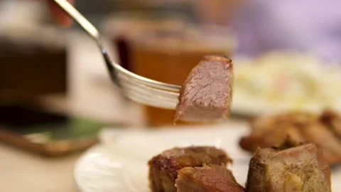 Cut the shashlik with a fork and knife fried meat in a plate vertical video Stock Footage 291938323