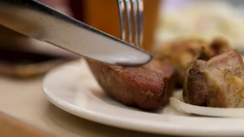 Cut the shashlik with a fork and knife Stock Footage 291938622