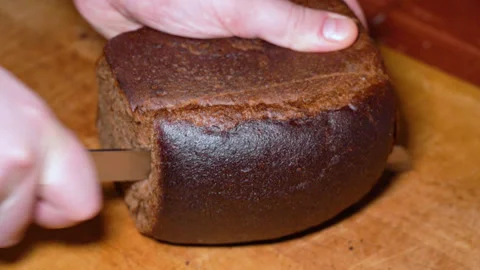 Cut slice of black bread on wooden board Stock Footage 247561526