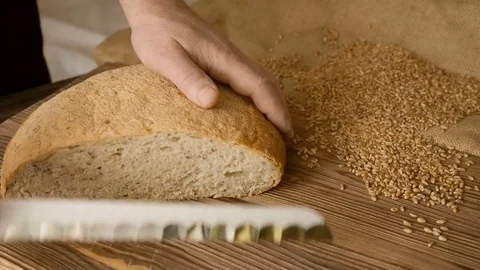 Cut slice of bread on the wooden table, in slow motion, close up Stock Footage 72899004