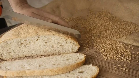 Cut slice of bread on the wooden table, in slow motion, close up Stock Footage 72915695