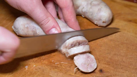 Cut slice of fresh homemade raw sausages on a wooden board Stock-Footage 247561444