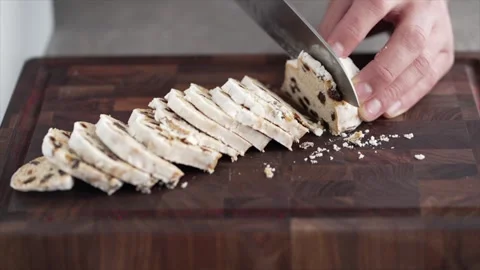 Cut the stollen with a knife into small slices on a chopping board Stock Footage 261071349
