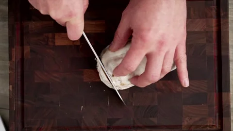 Cut the stollen with a knife into small slices on a chopping board Видео 261071459