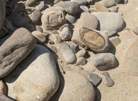 A cut of stone, pebbles with different layers of minerals. Stock Photos