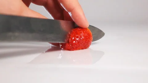 Cut strawberry on white surface by knife Stock Footage 63080052
