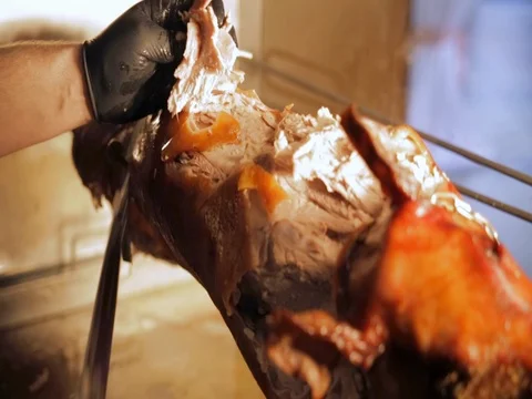 Cut the suckling pig on a spit Stock Footage 75563395