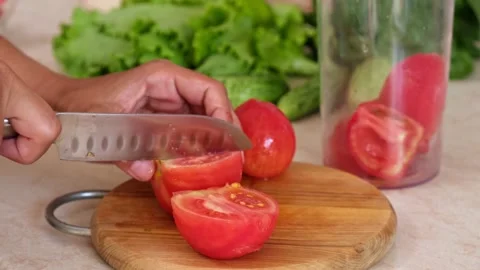 Cut tomatoes on wooden board. Preparing tomato sauce at home. Stock Footage 158598561