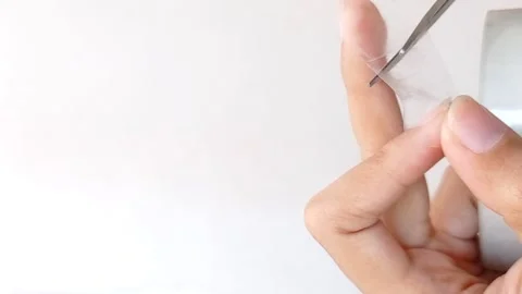 Cut a transparent plastic with a scissor Stock Footage 145562098