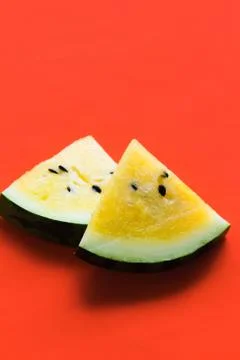 Cut off triangular slices of ripe yellow watermelon on white background Foto stock