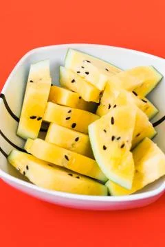 Cut off triangular slices of ripe yellow watermelon in white plate 写真素材