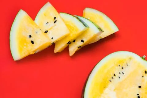 Cut off triangular slices of ripe yellow watermelon on white background Stock Photos