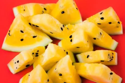 Cut off triangular slices of ripe yellow watermelon on white background Stock Photos