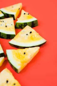Cut off triangular slices of ripe yellow watermelon on white background Stock Photos