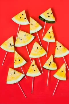 Cut off triangular slices of ripe yellow watermelon on white background Stockfoto's