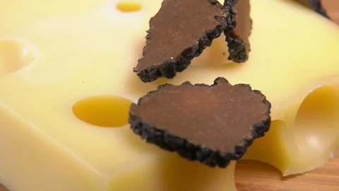 Cut truffle slices fall onto cheese with holes Stock-Footage 302847652