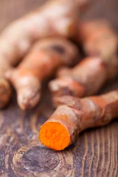Cut tumeric on dark wood Stock Photos