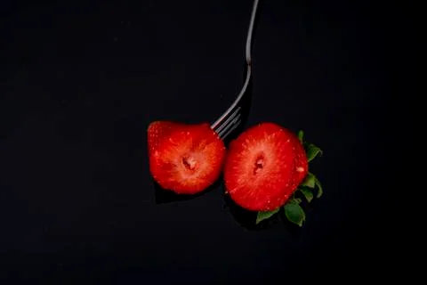 Cut in two halves with a fork on black background dark Stock Photos