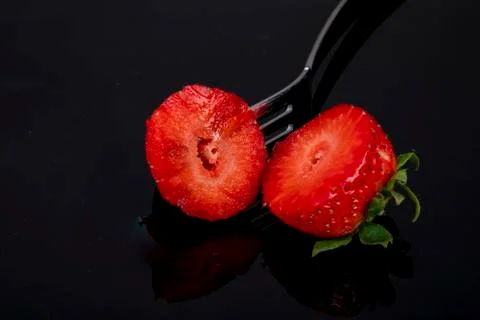 Cut in two halves with a fork on black background dark Stock Photos