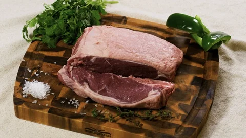 Cut of uncooked meat with cilantro, pepper and sea salt Stockbeeldmateriaal 102610028