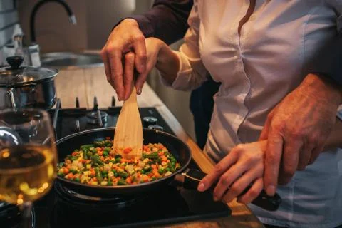 Cut view and close up. Man helping woman to cook dinner. He hold his handson Foto stock