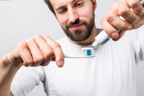 Cut view of a man putting some tooth paste on a tooth brush. He wants to clea Stockfoto's