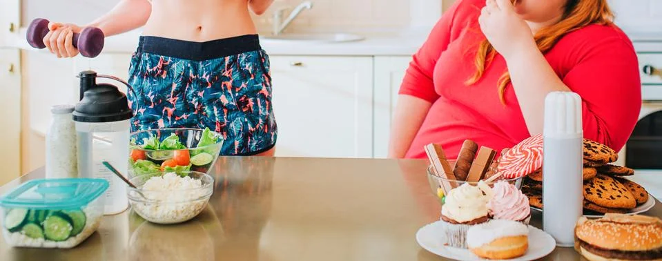 Cut view of young slim model and overweight woman in kitchen. Well-built girl Stock Photos