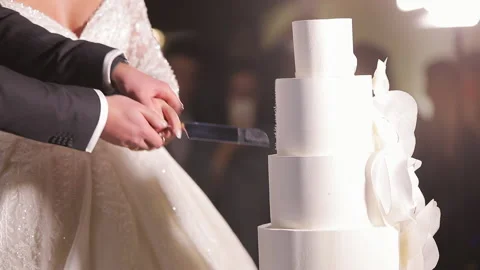 Cut the wedding cake. The bride and groom cut the wedding cake. Detail of Video stock 196004043