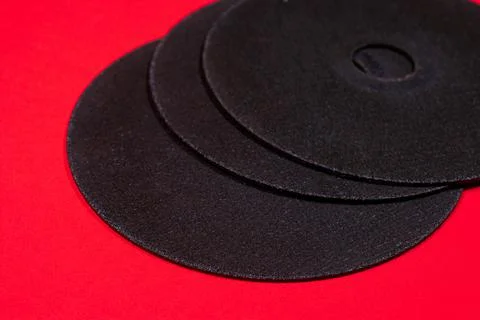 A cut-off wheel for a grinder tool on a red background. Stock Photos
