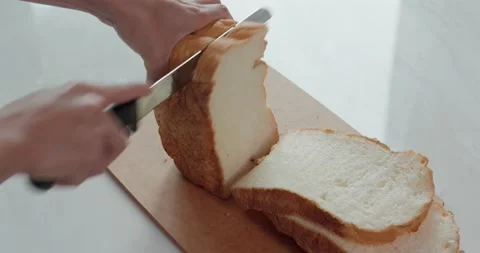 Cut a white bread with knife Stock Footage 132699430