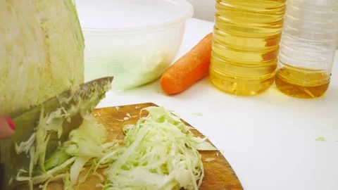 Cut white cabbage with a sharp knife.Shred fresh vegetables on a wooden Board. Vídeos de archivo 130629862
