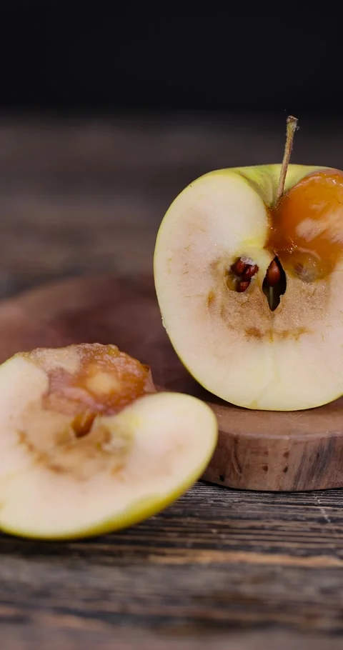 A cut yellow apple with a large orange spot during rotting, one rotting apple on Stock Footage 328095245