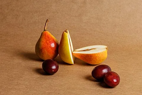 Cut yellow assorted pears, two pears and plums on kraft paper Stock Photos