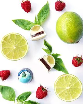 Cutaway chocolate candy. Raspberry, lime and basil on white. Top View Stock Photos