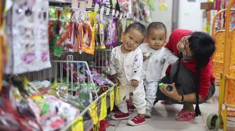 Cute 1 year old boy and girl twins babies and mother playing in the supermarket Stock Footage 68472894