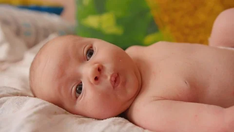 Cute 2 weeks old newborn baby is awning on the bed. Close up shot. 스톡 동영상 111774327