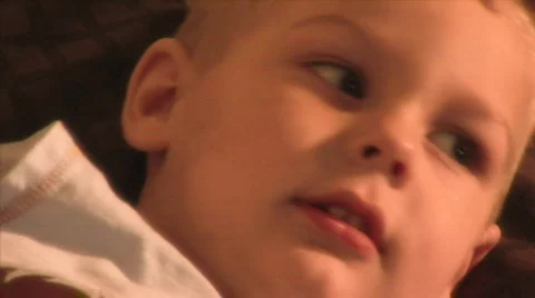 Cute 2 year old boy CU on sofa 1 release HD Stock Footage 345770