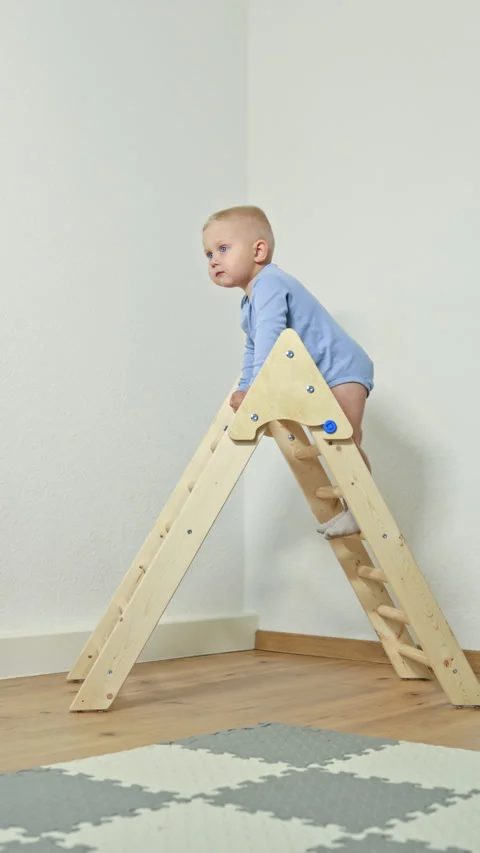 Cute 2 year old boy climbing a toy ladder. Development of balance in a toddler Stock Footage 319932112
