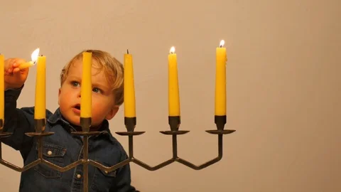 Cute 2 years old boy ignite Menorah dolly shot Stock Footage 104610967