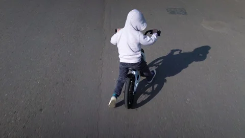 Cute 3 - 4 years boy child learning to ride first running balance bike. Stock Footage 113362614