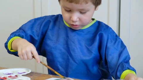 Cute 4 years old blond boy drawing with gouache Stockbeeldmateriaal 102819472