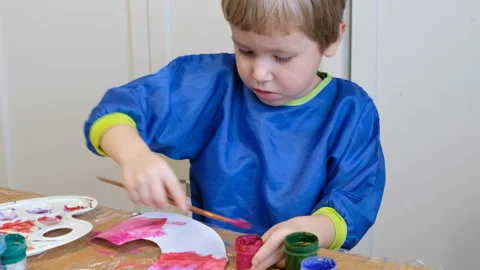 Cute 4 years old blond boy drawing with gouache Stock Footage 102819822