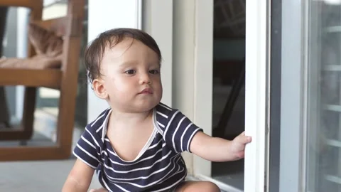A cute 8-10 month old baby explores the world and learns the work of opening a Stock Footage 172563590