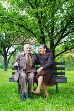 Cute 80 plus year old married couple posing for a portrait in their garden. Stock Photos