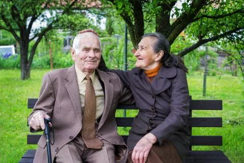 Cute 80 plus year old married couple posing for a portrait in their garden. Stock Photos