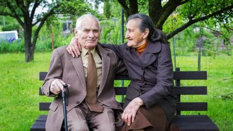 Cute 80 plus year old married couple posing for a portrait in their garden. Stock Photos